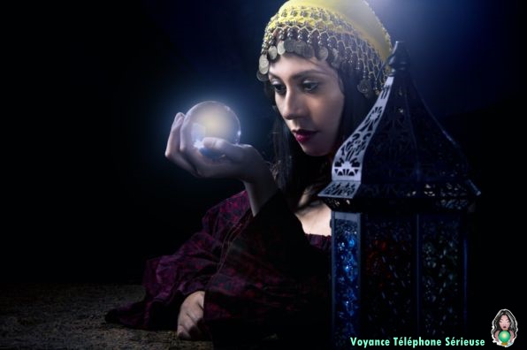 une voyante sérieuse lit l'avenir dans une boule de cristal